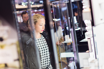 Image showing Beautiful woman standing in front of showcase.