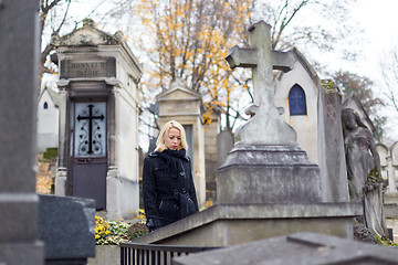 Image showing Solitary woman visiting relatives grave.