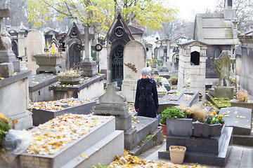 Image showing Solitary woman visiting relatives grave.