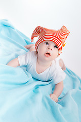 Image showing toddler in a striped hat on a blue blanket