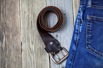 Image showing Vintage blue jeans and old leather belt