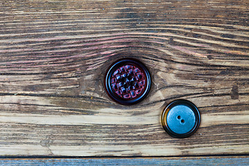 Image showing two vintage buttons on aged wood surface