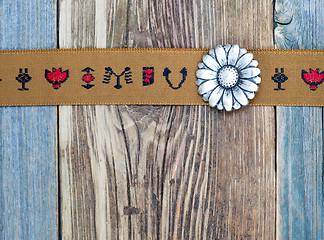 Image showing vintage band with embroidered ornaments and old button flower