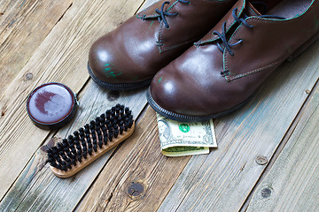 Image showing boots, brush, shoe polish and dollar