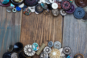 Image showing set of vintage buttons on aged boards of old table