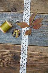 Image showing still life with lace ribbon, vintage buttons, spools of thread a