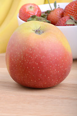 Image showing Fruits. Arrangement of various fresh ripe fruits: bananas, apple and strawberries closeup