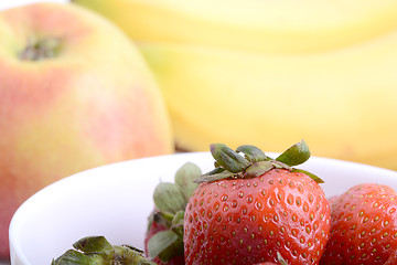 Image showing Fruits. Arrangement of various fresh ripe fruits: bananas, apple and strawberries closeup