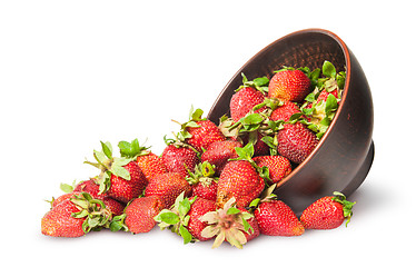 Image showing Scattered ripe juicy strawberries in a ceramic bowl