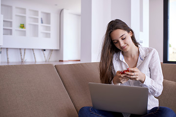 Image showing relaxed young woman at home working on laptop computer