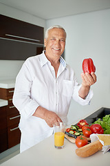 Image showing man cooking at home preparing salad in kitchen