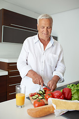 Image showing man cooking at home preparing salad in kitchen