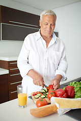 Image showing man cooking at home preparing salad in kitchen