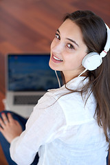 Image showing relaxed young woman at home working on laptop computer