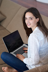 Image showing relaxed young woman at home working on laptop computer