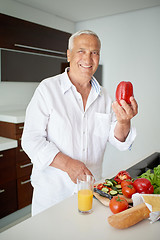 Image showing man cooking at home preparing salad in kitchen