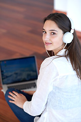 Image showing relaxed young woman at home working on laptop computer