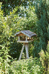 Image showing Three-legged wooden bird table