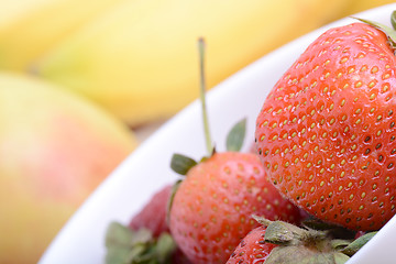 Image showing Fruits. Arrangement of various fresh ripe fruits: bananas, apple and strawberries closeup