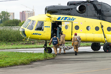 Image showing Rescuers load into helicopter MI-8 