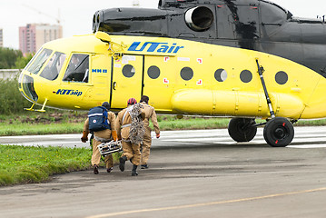 Image showing Rescuers load into helicopter MI-8 