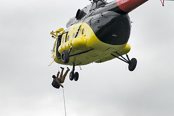 Image showing Rescuer is landed from MI-8 helicopter by rope