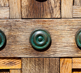 Image showing in london antique brown door  rusty  brass nail and light