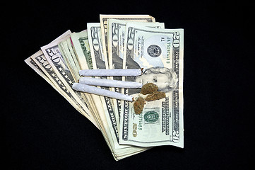 Image showing fanned money with marijuana on black