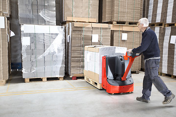 Image showing Worker Pushing Stock On Handtruck