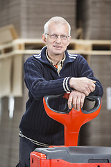 Image showing Confident Worker Leaning On Handtruck