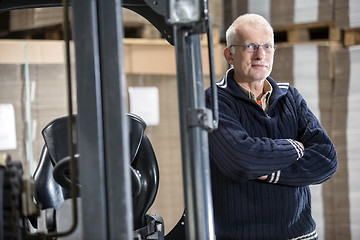 Image showing Confident Worker Leaning On Forklift