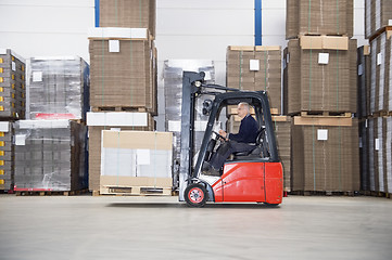 Image showing Supervisor Driving Forklift In Warehouse