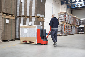 Image showing Worker Pushing Handtruck Loaded With Goods