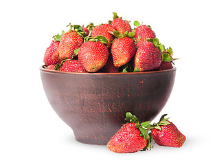 Image showing Ripe juicy strawberries in a ceramic bowl and two near