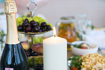 Image showing Candle and champagne bottle on table