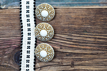 Image showing Vintage ribbon with embroidered pattern and three ancient button