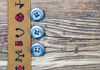 Image showing vintage tape with embroidered ornaments and three old button