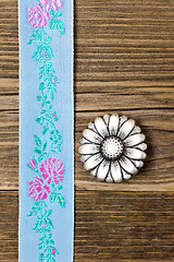 Image showing vintage aqua color tape with embroidered ornaments and old butto