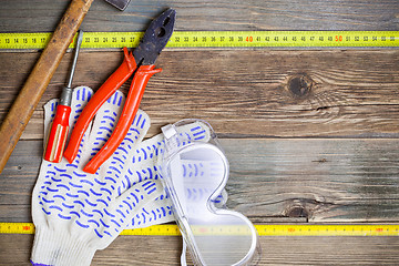 Image showing vintage hammer, pliers, screwdriver, tape measure, gloves and sa