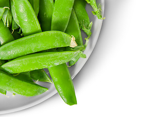 Image showing Closeup green peas in pods on white plate top view