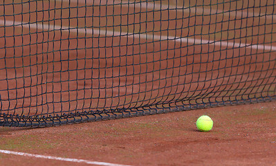 Image showing Tennis ball on the orange tenniscourt