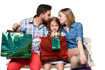 Image showing Happy family with shopping bags sitting at studio 