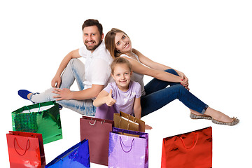 Image showing Happy family with shopping bags sitting at studio 