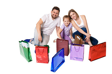 Image showing Happy family with shopping bags sitting at studio 