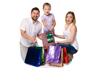 Image showing Happy family with shopping bags sitting at studio 