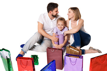 Image showing Happy family with shopping bags sitting at studio 