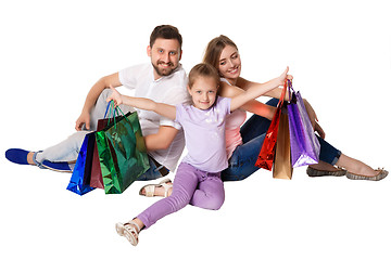 Image showing Happy family with shopping bags sitting at studio 