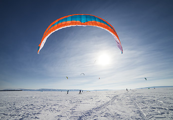 Image showing Kiteboarder with blue kite on the snow