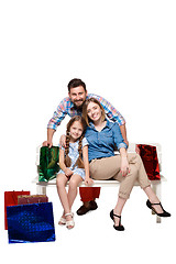 Image showing Happy family with shopping bags sitting at studio 