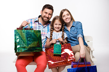 Image showing Happy family with shopping bags sitting at studio 